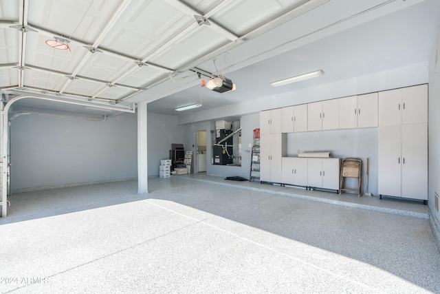 garage featuring a garage door opener and heating unit