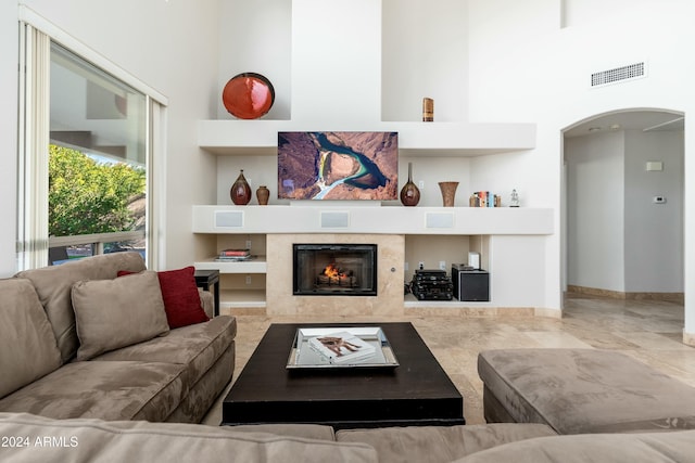 living room featuring a fireplace and a towering ceiling