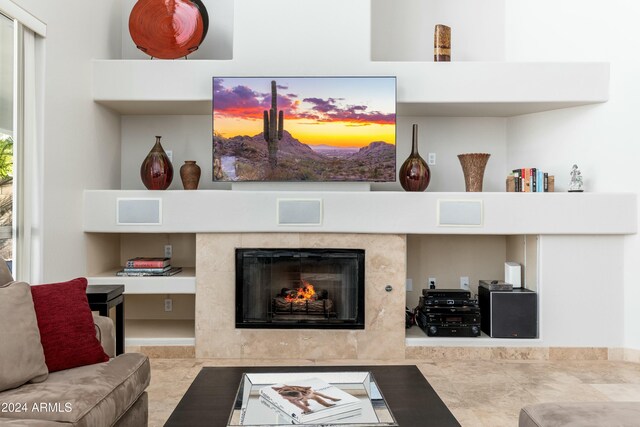 living room featuring a high end fireplace and built in features