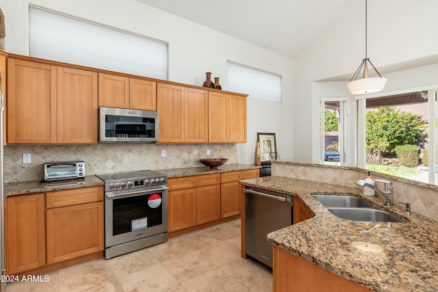 kitchen with backsplash, decorative light fixtures, sink, and appliances with stainless steel finishes