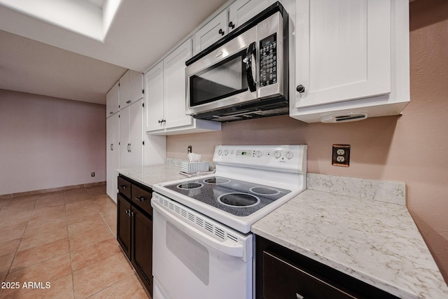 4916 E Hopi St, Phoenix, AZ 85044 - kitchen featuring light stone counters, white range with electric cooktop, stainless steel microwave, white cabinetry, and light tile patterned flooring