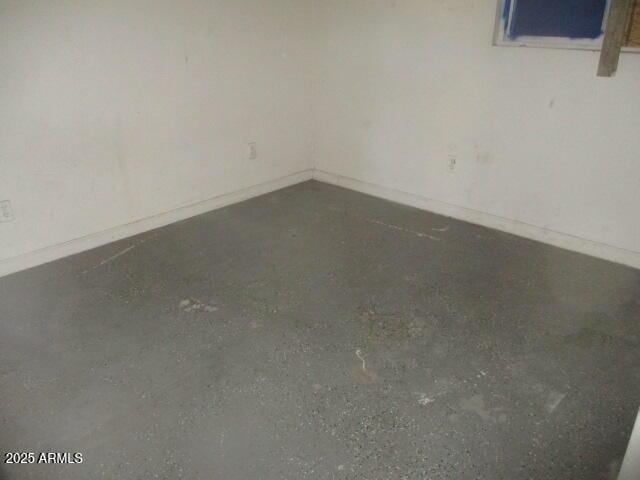 unfurnished room with baseboards