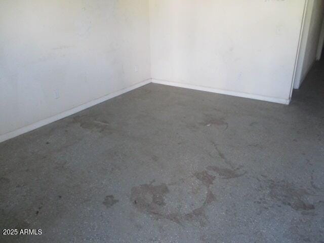 unfurnished room featuring baseboards