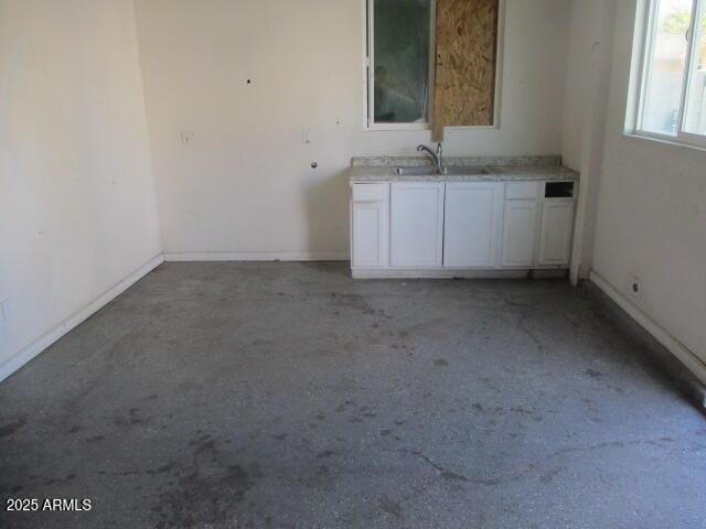 empty room with baseboards and a sink