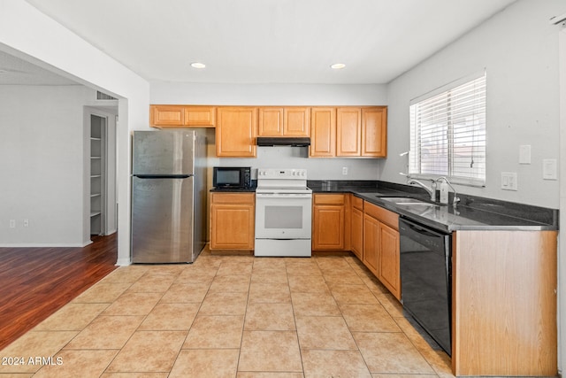 kitchen featuring black appliances, light wood-type flooring, and sink