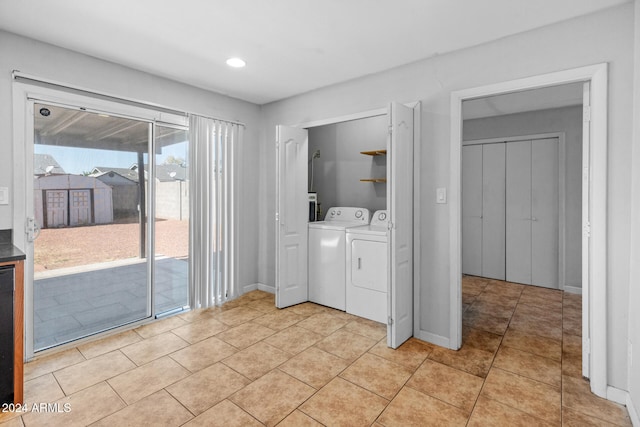 laundry area with light tile patterned floors and washing machine and clothes dryer