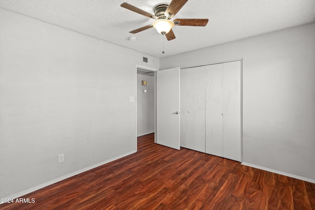 unfurnished bedroom featuring a textured ceiling, dark hardwood / wood-style flooring, a closet, and ceiling fan