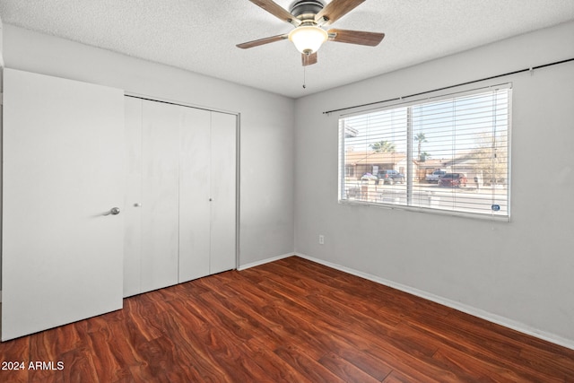 unfurnished bedroom with a textured ceiling, ceiling fan, a closet, and dark hardwood / wood-style floors