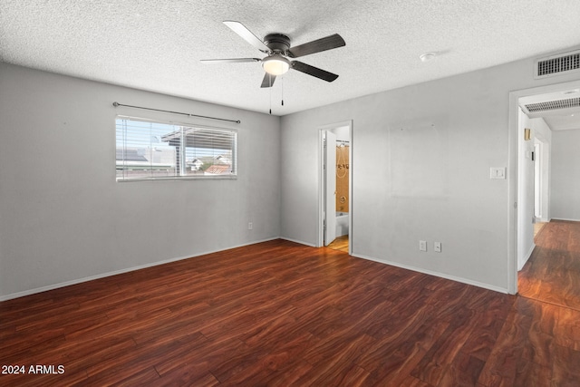 empty room with ceiling fan, dark wood-type flooring, and a textured ceiling