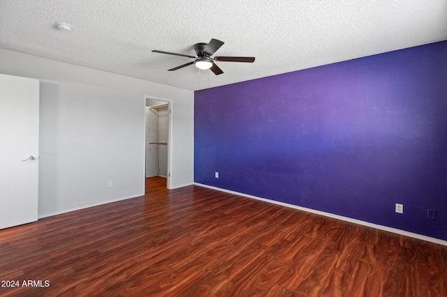 spare room with ceiling fan, dark wood-type flooring, and a textured ceiling