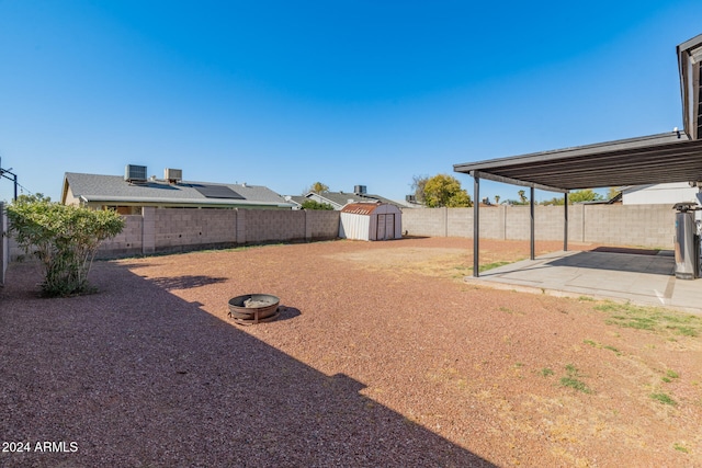 view of yard featuring a shed and a patio area