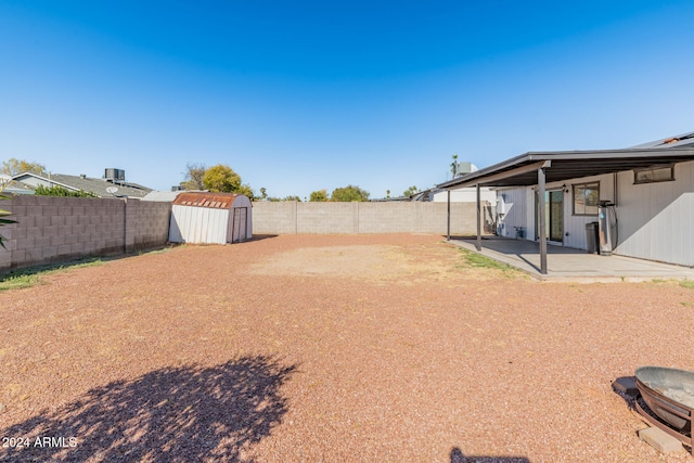 view of yard featuring a storage shed and a patio