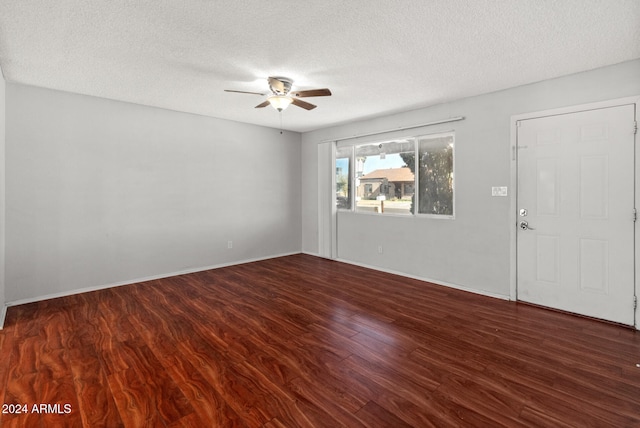 empty room featuring ceiling fan, dark hardwood / wood-style flooring, and a textured ceiling