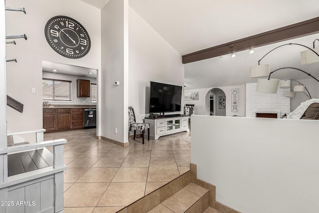 3358 W Sandra Ter, Phoenix, AZ 85053 - living area with arched walkways, light tile patterned floors, baseboards, beam ceiling, and high vaulted ceiling