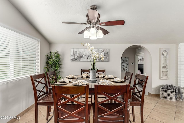 3358 W Sandra Ter, Phoenix, AZ 85053 - dining area with light tile patterned flooring, arched walkways, ceiling fan, and baseboards