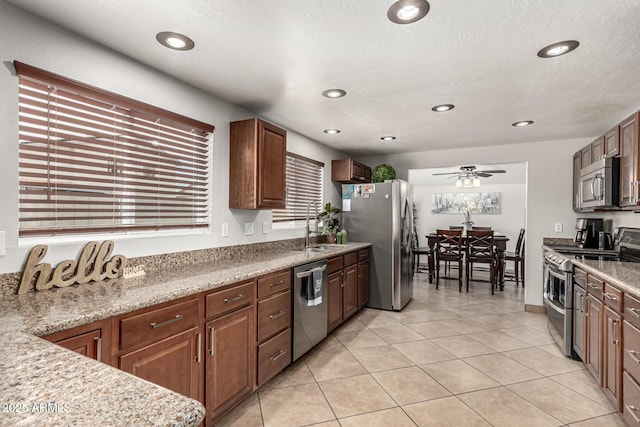 3358 W Sandra Ter, Phoenix, AZ 85053 - kitchen with stainless steel appliances, light tile patterned floors, a ceiling fan, recessed lighting, and a sink