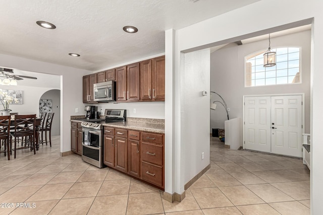 3358 W Sandra Ter, Phoenix, AZ 85053 - kitchen featuring appliances with stainless steel finishes, arched walkways, light tile patterned floors, a ceiling fan, and recessed lighting