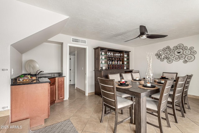3358 W Sandra Ter, Phoenix, AZ 85053 - dining room featuring bar, light tile patterned floors, ceiling fan, a textured ceiling, and baseboards
