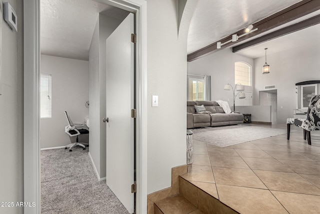 3358 W Sandra Ter, Phoenix, AZ 85053 - hallway featuring beamed ceiling, plenty of natural light, arched walkways, and tile patterned flooring