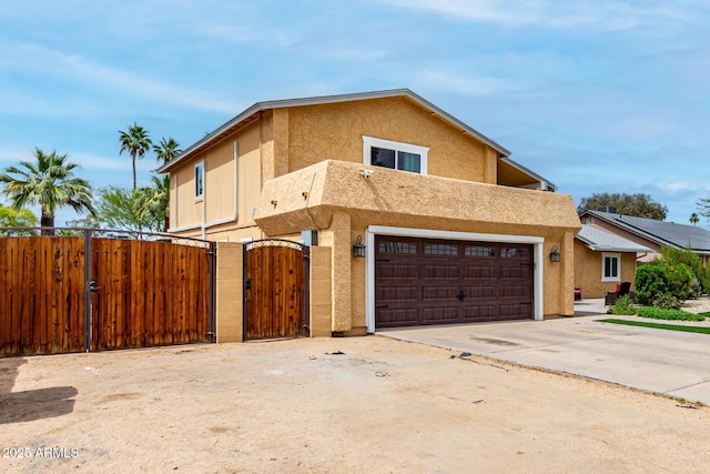 3358 W Sandra Ter, Phoenix, AZ 85053 - townhome / multi-family property with a gate, stucco siding, driveway, and an attached garage