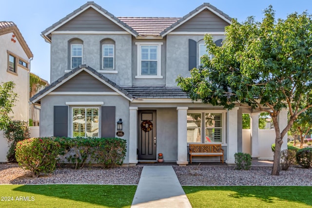 traditional-style home featuring a tile roof and stucco siding