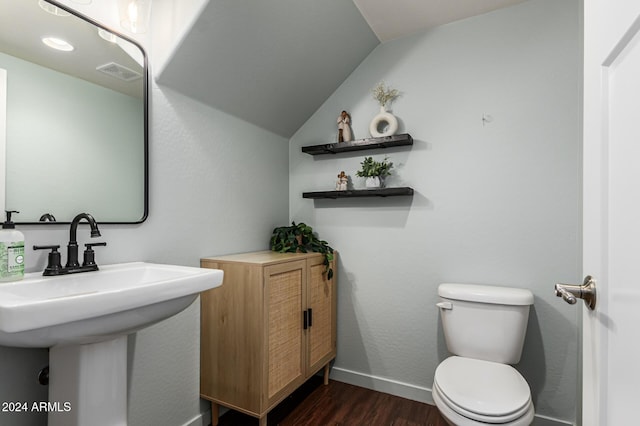 bathroom featuring baseboards, visible vents, toilet, wood finished floors, and vaulted ceiling