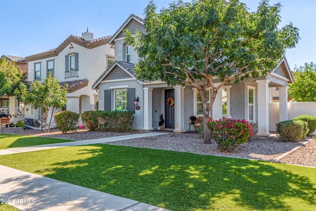 view of front of property with fence, a tiled roof, stucco siding, a chimney, and a front yard