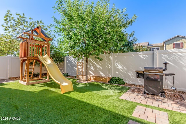 view of playground with a fenced backyard and a yard