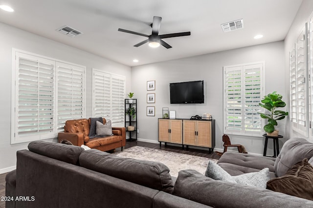 living area with a ceiling fan, dark wood-style flooring, visible vents, and baseboards