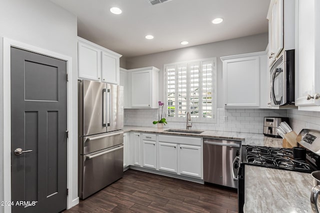 kitchen with stainless steel appliances, dark wood-style flooring, white cabinets, and a sink