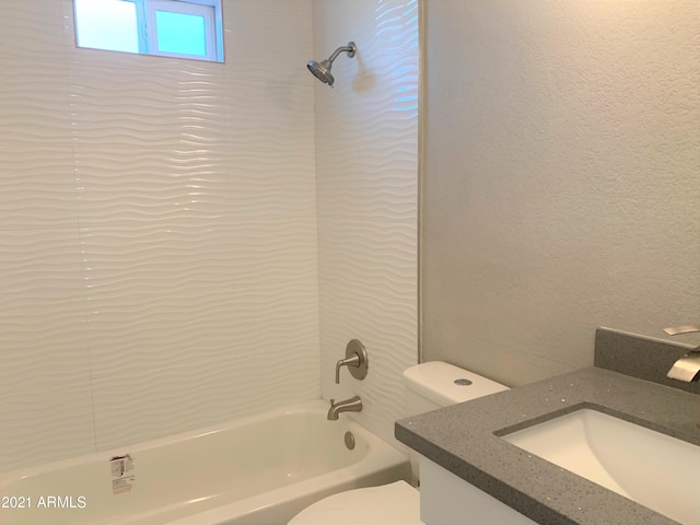 bathroom featuring a textured wall, shower / tub combination, vanity, and toilet