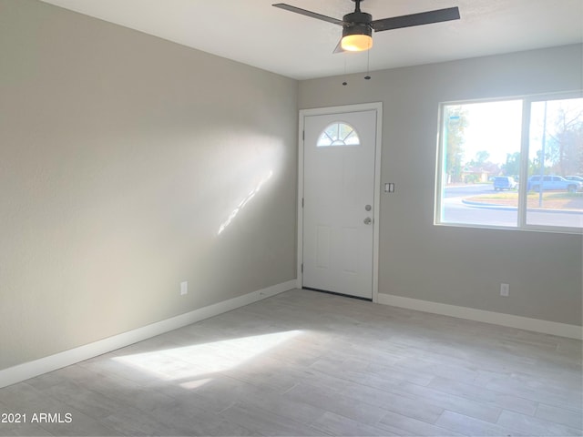 entryway featuring ceiling fan, light wood-style flooring, and baseboards