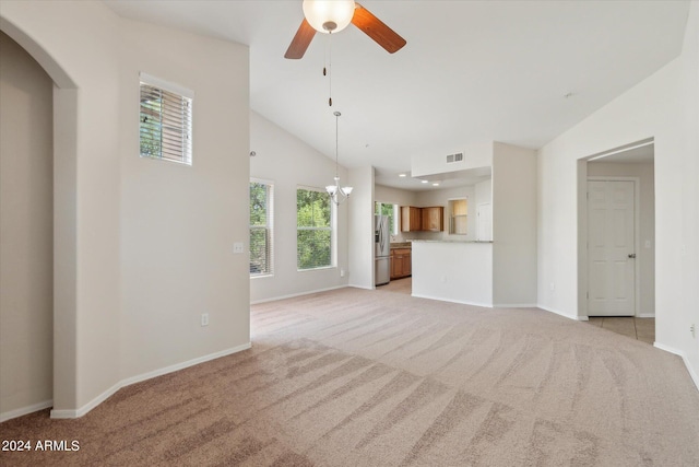 unfurnished living room featuring ceiling fan with notable chandelier, baseboards, visible vents, and light carpet