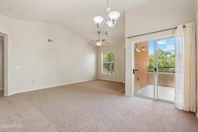 carpeted empty room with visible vents, ceiling fan with notable chandelier, high vaulted ceiling, and baseboards