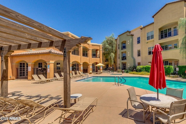 community pool with a patio area and a pergola