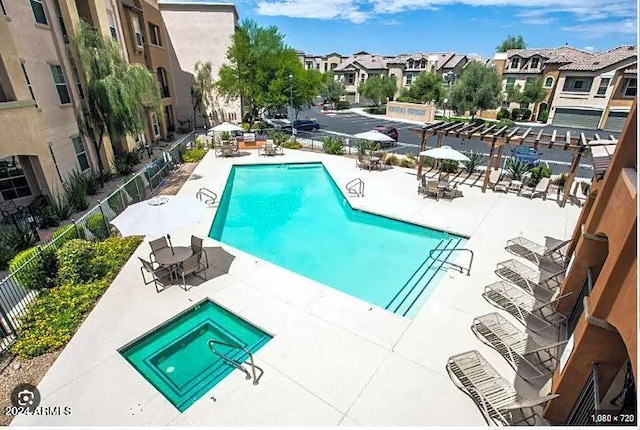 community pool featuring a residential view, a patio, and fence