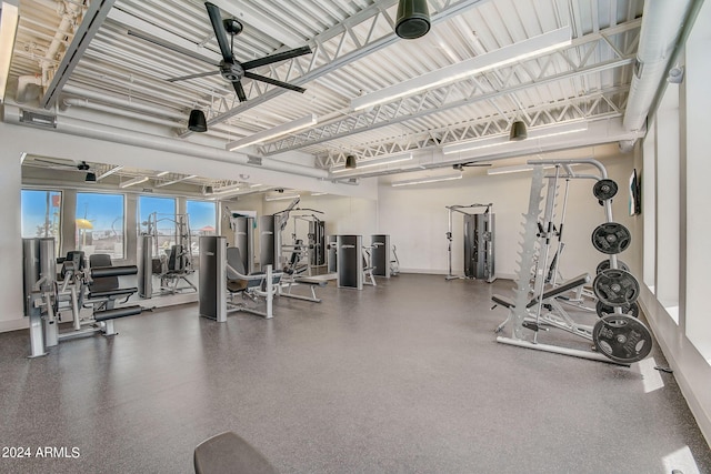 exercise room featuring a ceiling fan and baseboards