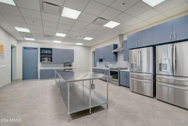 kitchen with wall chimney range hood, open shelves, blue cabinetry, and stainless steel appliances