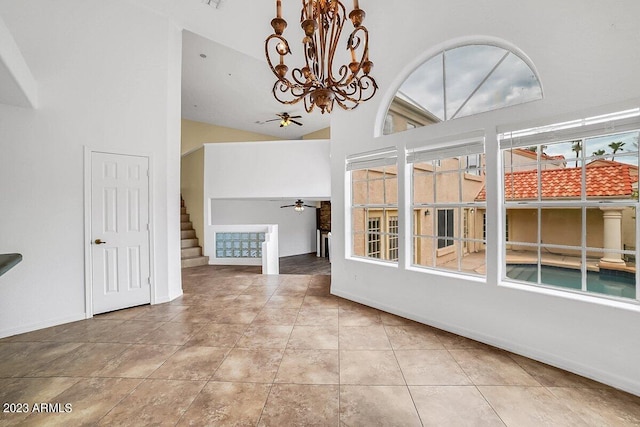 unfurnished dining area with light tile patterned flooring, a chandelier, and high vaulted ceiling