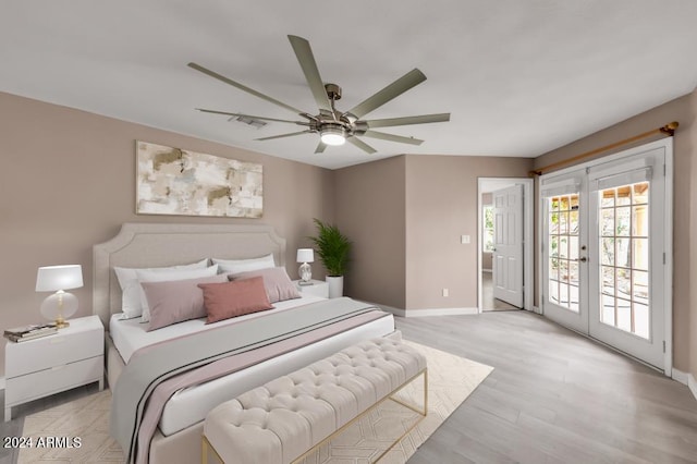 bedroom featuring access to exterior, french doors, light hardwood / wood-style flooring, and ceiling fan