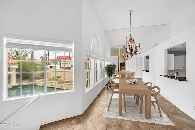 unfurnished dining area with a chandelier, a high ceiling, and light tile patterned floors