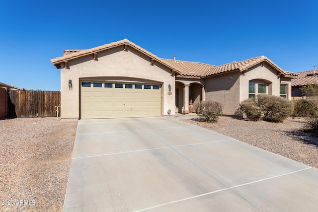 mediterranean / spanish home featuring driveway, an attached garage, a tile roof, and stucco siding