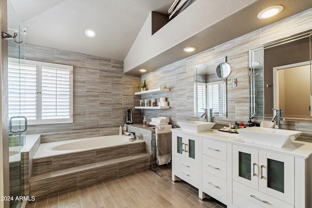 bathroom featuring a healthy amount of sunlight, tile walls, and lofted ceiling