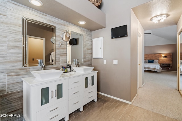 bathroom featuring vanity and tile walls