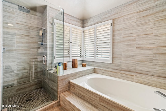 bathroom featuring independent shower and bath