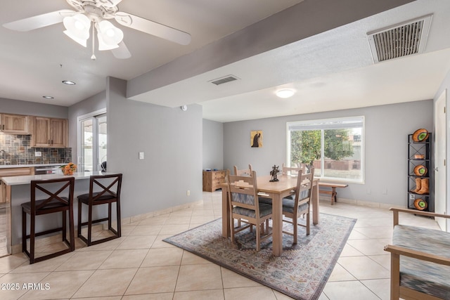 tiled dining room featuring a healthy amount of sunlight