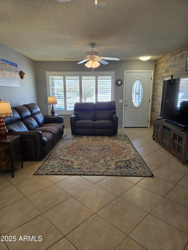 tiled living room featuring ceiling fan and a textured ceiling