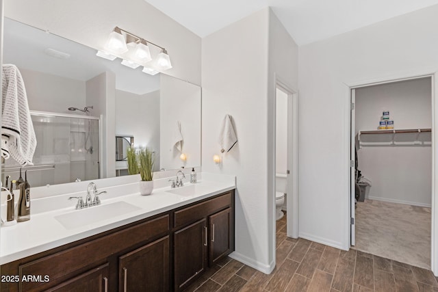 bathroom featuring vanity, toilet, and an enclosed shower