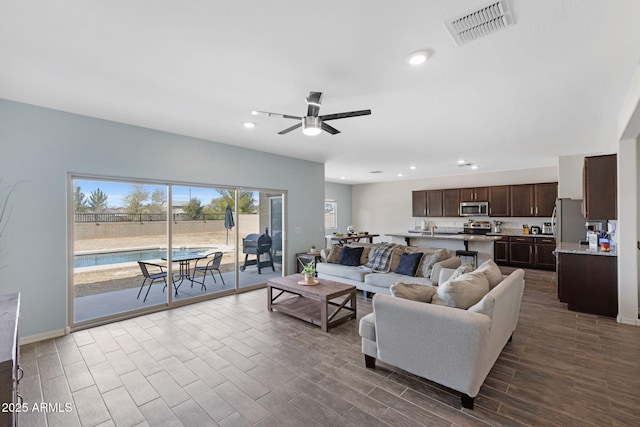 living room featuring hardwood / wood-style floors and ceiling fan