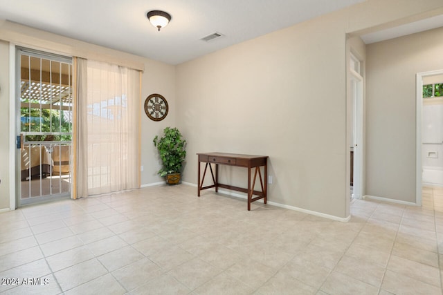 tiled empty room featuring a wealth of natural light